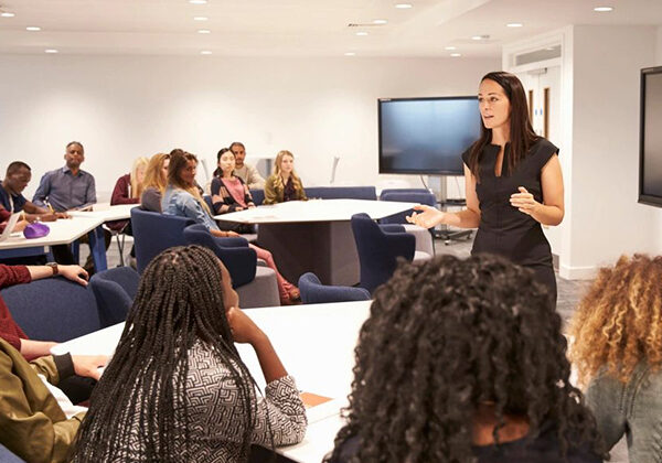 A woman presenting to a diverse group in a conference room.